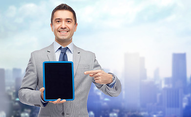 Image showing happy businessman in suit showing tablet pc screen