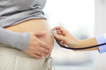 Image showing close up of pregnant woman belly and doctor hand