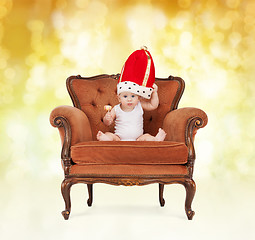 Image showing baby in royal hat with lollipop sitting on chair