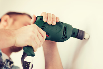 Image showing man with electric drill making hole in wall
