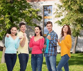 Image showing group of smiling teenagers over campus background