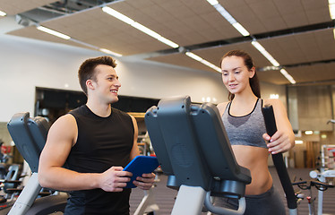 Image showing woman with trainer exercising on stepper in gym