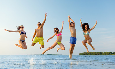 Image showing smiling friends in sunglasses on summer beach