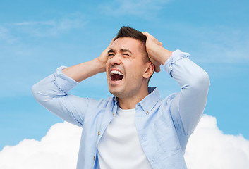 Image showing unhappy man with closed eyes touching his forehead