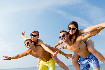 Image showing smiling friends having fun on summer beach