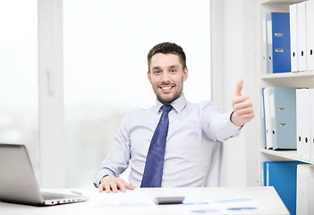 Image showing smiling businessman with laptop and documents