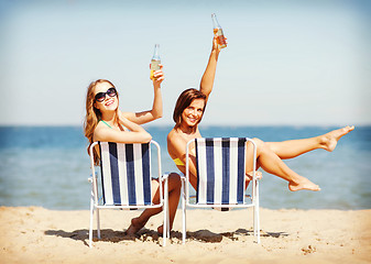 Image showing girls sunbathing on the beach chairs