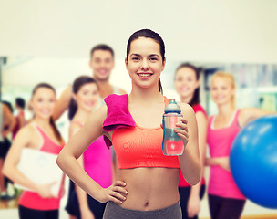 Image showing sporty woman with towel and water bottle