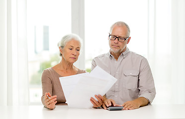 Image showing senior couple with papers and calculator at home