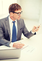 Image showing businessman working with laptop and smartphone