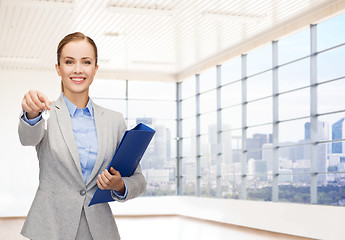 Image showing smiling businesswoman with folder and keys