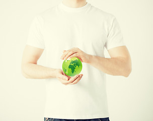 Image showing man hands holding green sphere globe