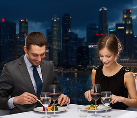 Image showing smiling couple eating main course at restaurant