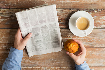 Image showing close up of male hands with newspaper and coffee