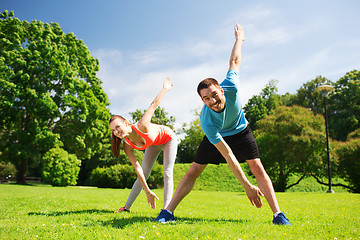 Image showing smiling couple stretching outdoors