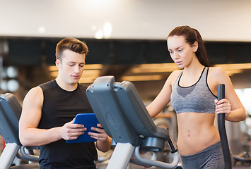 Image showing woman with trainer exercising on stepper in gym