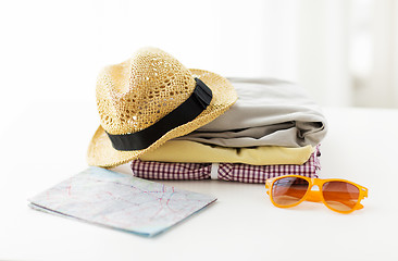 Image showing close up of summer clothes and travel map on table