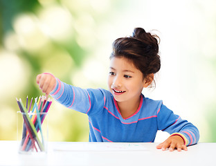 Image showing happy little girl drawing with coloring pencils