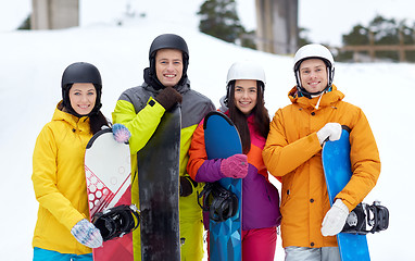 Image showing happy friends in helmets with snowboards