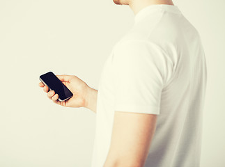Image showing man with smartphone typing something