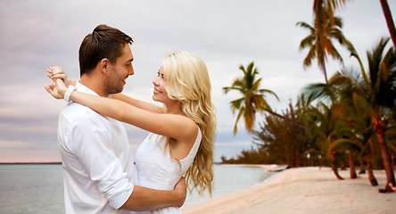 Image showing happy couple hugging over beach background