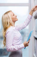 Image showing smiling businesswoman or secretary in office