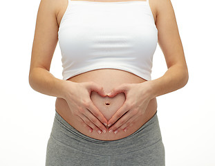 Image showing close up of pregnant woman touching her bare tummy