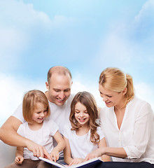 Image showing happy family with book at home