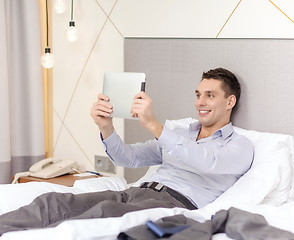 Image showing happy businesswoman with tablet pc in hotel room