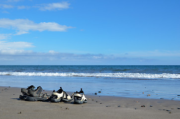 Image showing Two pair of sandals at a beach