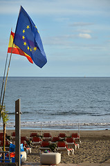 Image showing Flags at the beach with sunbeds