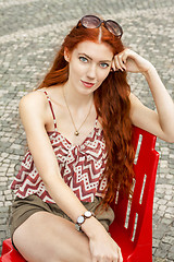 Image showing Pretty Blond Woman Sitting on Red Chair