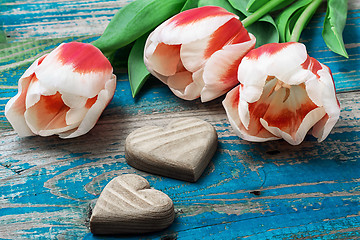 Image showing three hand-carved wooden heart with bouquet tulips