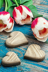 Image showing three hand-carved wooden heart with bouquet tulips