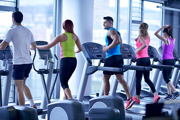 Image showing Group of people running on treadmills