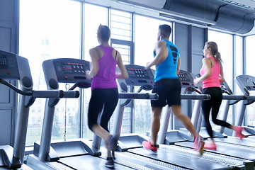 Image showing Group of people running on treadmills