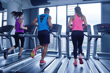 Image showing Group of people running on treadmills