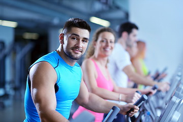 Image showing Group of people running on treadmills