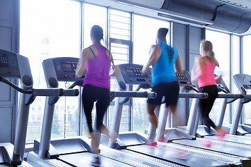 Image showing Group of people running on treadmills