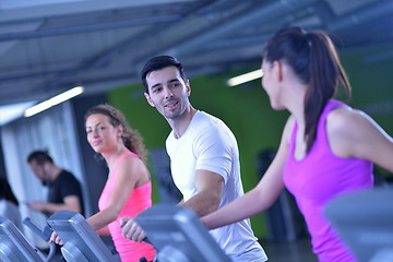 Image showing Group of people running on treadmills