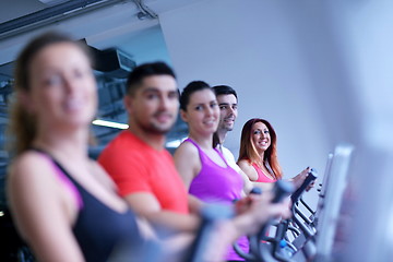 Image showing Group of people running on treadmills