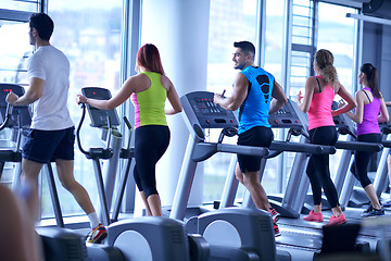 Image showing Group of people running on treadmills