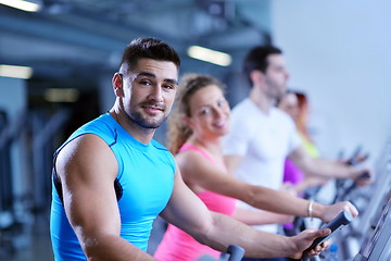 Image showing Group of people running on treadmills