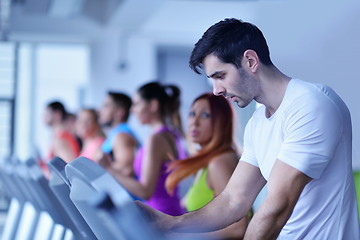 Image showing Group of people running on treadmills