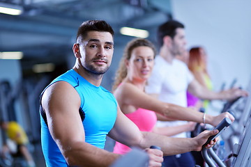 Image showing Group of people running on treadmills