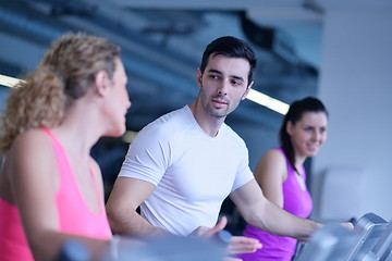 Image showing Group of people running on treadmills