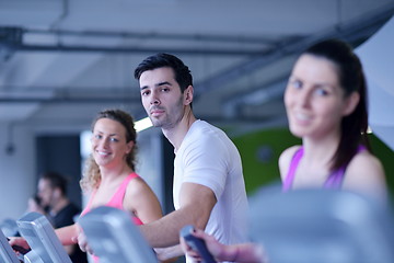 Image showing Group of people running on treadmills