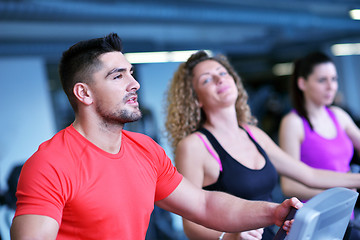 Image showing Group of people running on treadmills