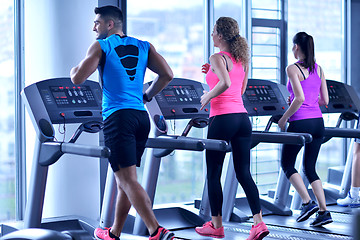 Image showing Group of people running on treadmills