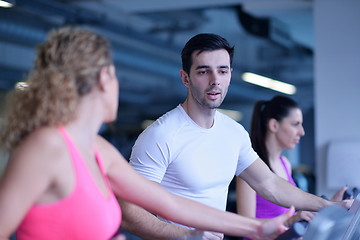 Image showing Group of people running on treadmills